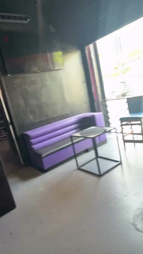 Purple leather booth beside a garage-door opening to the patio